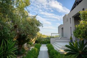 a garden with a walkway between two buildings at Reina del Cielo Luxury Villa in Pýrgos
