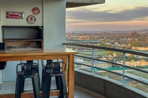 un balcon avec deux tabourets de bar et une vue sur une ville dans l'établissement Departamento premium a estrenar, à Villa Luján