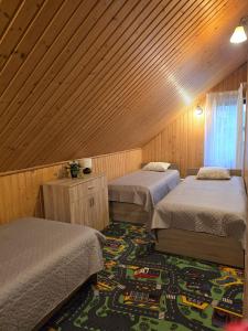 a room with two beds and a rug at Brīvdienu māja pie Gaujas in Siguļi +19 photos