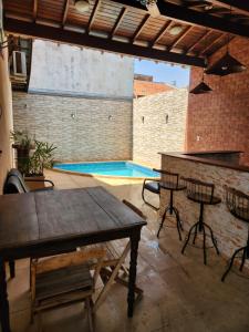 a patio with a table and chairs and a swimming pool at Recanto do Bem-Te-Vi in Olímpia