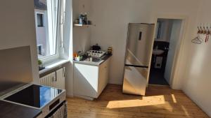a kitchen with a refrigerator and a wooden floor at City Central Apartment House in Kaiserslautern