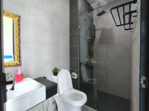 a bathroom with a toilet and a sink and a shower at Big Family stay urban Large Pool & Sea view Netfix in Jelutong +44 photos