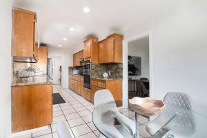 a kitchen with wooden cabinets and a table and chairs at Updated 3-Bedroom LA Home with Backyard, BBQ & Family-Friendly Amenities in Los Angeles +38 photos