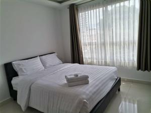 パタヤ・サウスにあるCozy 2BR 2Bath condo in Central Pattayaの白いベッド(上にボックス付)