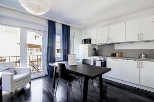 a kitchen with white cabinets and a table in a kitchen at Sweet-Neipperg in Luxembourg