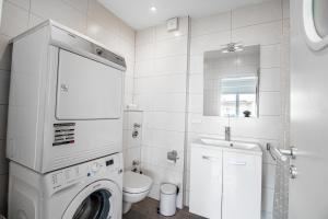 a bathroom with a washing machine and a sink at Sweet-Neipperg in Luxembourg