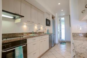 a kitchen with white cabinets and stainless steel appliances at Maui Eldorado Condo K206 in Kaanapali