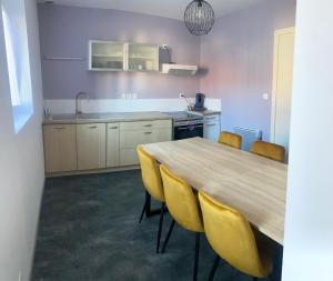 una cucina con tavolo in legno e sedie gialle di À louer, charmante maison à Douai a Douai