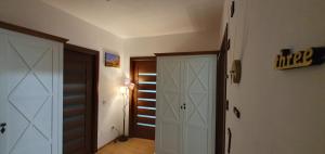 a hallway with a white closet and a door at Apartament Relaxa Green 3 - 2 Rooms - AC - Parking in Târgu-Mureş