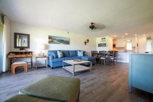 a living room with a blue couch and a table at Maui Eldorado Condo A204 in Kaanapali
