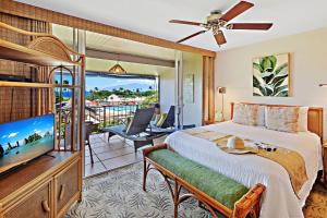 a bedroom with a bed and a tv and a balcony at Maui Eldorado Condo F203 in Kaanapali
