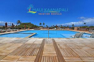 a swimming pool at a resort with a wooden deck at Maui's Newest 2 BR - California Coastal Inspired in Kaanapali