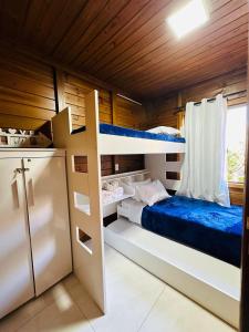 a bedroom with two bunk beds in a cabin at Woodhouse Tranquilidade e Conforto no Paraíso, piscina aquecida e ar condicionado in Alto Paraíso de Goiás