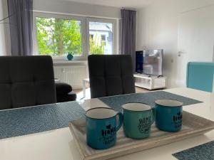 a table with three blue cups on a wooden tray at Ferienwohnung Sieben, Zentral gelegene mit Tiefgaragenstellplatz in Bad Oeynhausen
