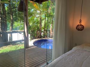 a bedroom with a view of a pool through a glass door at Villas Supreme Apartamentos in Maceió +21 photos