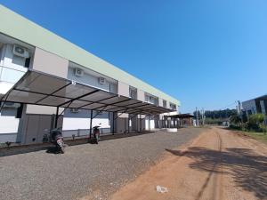 a building with awning next to a dirt road at Agua de Vida- Parque Termal Chajarí in Chajarí