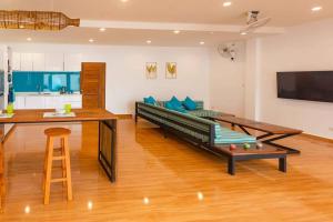 un salon avec un canapé et un bar dans l'établissement Amidst tropical plantations and striking mountain views, à Ban Khlong Haeng