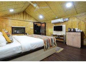 a bedroom with a large bed and a kitchen at Hotel Arcadia plutus in Jaipur