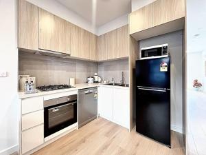 cocina con nevera negra y fogones en Family Home at Boronia, en Boronia