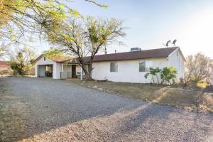 a white house with a tree and a gravel road at Lazy H Bar Desert Outpost Ranch House with Pool and Hot Tub in Tucson