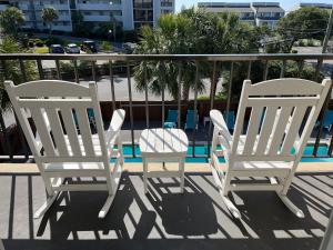 2 sillas blancas en un balcón con piscina en Summer Sands - 207 by Sea Scape Properties, en Wrightsville Beach