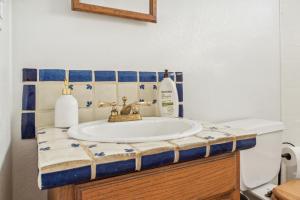 a bathroom sink with a blue and white tiles at Lazy H Bar Desert Outpost Ranch House with Pool and Hot Tub in Tucson