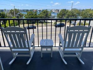 2 sillas en un balcón con vistas a un aparcamiento en Summer Sands - 201 by Sea Scape Properties, en Wrightsville Beach