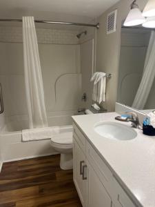 Un baño con lavabo, inodoro y bañera. en Summer Sands - 207 by Sea Scape Properties, en Wrightsville Beach