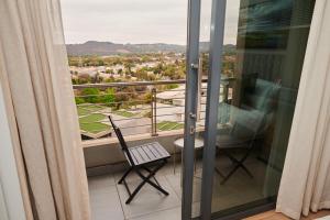 a balcony with a chair and a view of a city at When Away - Your Home Away from Home in Pretoria