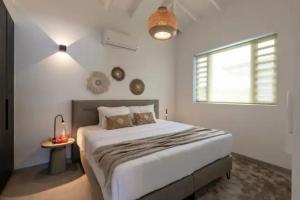 Un dormitorio con una cama grande y una ventana en Jan thiel Modern Apartments Curacao, en Jan Thiel 38 fotos más