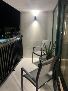 a balcony with two chairs and a table and a window at Amrita Hotel in Liepāja