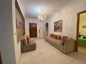 a living room with two couches and a chandelier at DAR SHaMSY in Souani