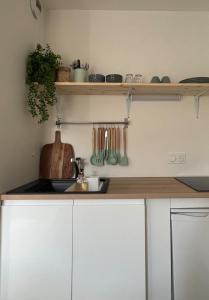 a kitchen with white cabinets and a counter top at LE COSY Sarrebourg Wifi Netflix Tout à pied Proche center parc Proche gare in Sarrebourg