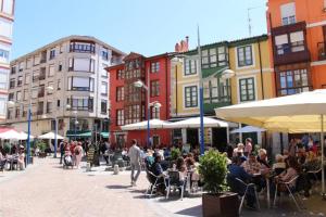 a group of people sitting at tables on a city street at Appartement avec terrasse in Santoña