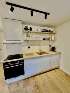a kitchen with a sink and a stove at Aurora Stay- Aurora garden Apartment in Tromsø