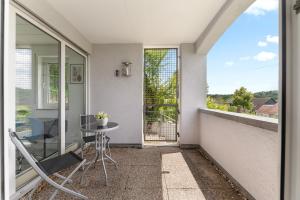 a balcony with a glass table and a table at Sunshine - 4 Personen Airport Messe mit TG-Garage in Ostfildern