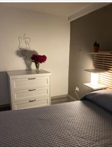 a bedroom with a dresser with a vase of flowers on it at La casa al teatro in Catania +18 photos