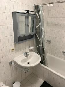 a white bathroom with a sink and a mirror at Schöne Wohnung für Tagesgäste, Studenten oder Handwerker, Chemnitz Gablenz, ÖPNV direkt vor der Tür, Internet & TV inkl in Chemnitz +27 photos