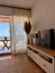 a living room with a large television and a balcony at Blue Home in Los Alcázares