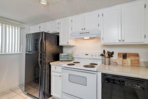 a kitchen with white cabinets and a stainless steel refrigerator at Pier Point 17 in St. Augustine