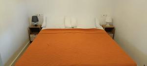 una camera da letto con un letto con una coperta arancione di Cortijo Ciprés a Vélez Blanco