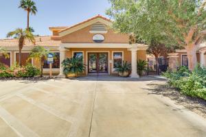 a building with palm trees in front of it at Near Golf Condo with Pool Access in Palm Desert! in Palm Desert