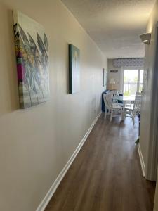 a hallway with a dining room and a dining table at Summer Sands - 302 by Sea Scape Properties in Wrightsville Beach