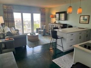 a living room with a couch and a table at Summer Sands - 406 by Sea Scape Properties in Wrightsville Beach