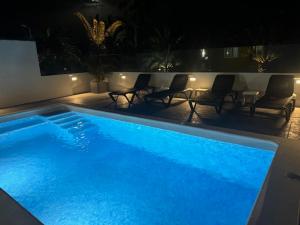 duży niebieski basen z krzesłami i światłami w obiekcie Villa La Era w mieście Fuencaliente de la Palma