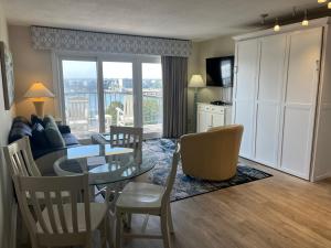 a living room with a table and chairs and a dining room at Summer Sands - 402 by Sea Scape Properties in Wrightsville Beach