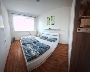 a bedroom with a large bed with blue sheets and a window at Apartman s terasou in Oščadnica