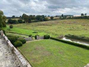 an aerial view of a green field with a river at Suite de charme au château de Cibioux in Surin