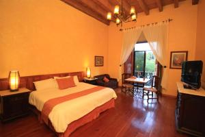 a bedroom with a large bed and a television at Hotel Ciudad Real Centro Historico in San Cristóbal de Las Casas