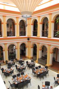 an empty restaurant with tables and chairs in a building at Hotel Ciudad Real Centro Historico in San Cristóbal de Las Casas